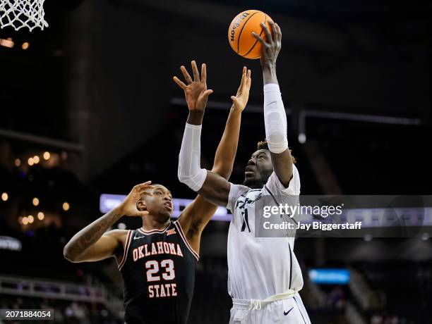 Ibrahima Diallo of the UCF Knights shoots against Brandon Garrison of the Oklahoma State Cowboys during the first half of the Big 12 Men's Basketball...