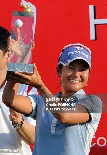 Ai Miyazato of Japan holds up the winner's trophy following her victory in the final round of the Golf Honda PTT LPGA Thailand 2010 golf tournament...