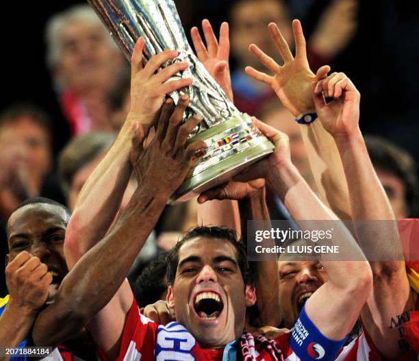 Atletico Madrid's captain Antonio Lopez and teammates players celebrate with the trophy after winning the final football match of the UEFA Europa...