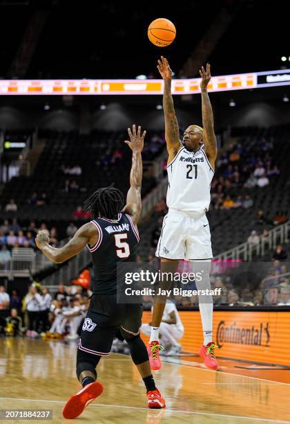 Walker of the UCF Knights shoots against Quion Williams of the Oklahoma State Cowboys during the first half of the Big 12 Men's Basketball Tournament...