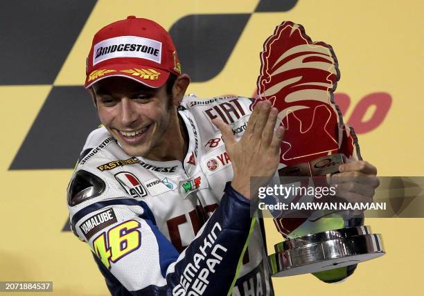 Nine-time Italian world champion Valentino Rossi of Fiat Yamaha team jubialtes after winning the MotoGP final race at the Losail International...