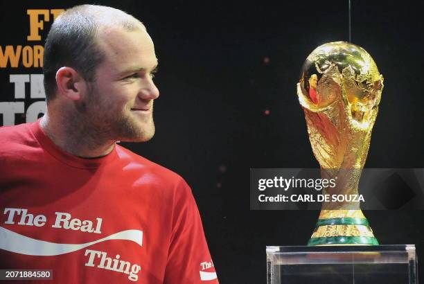 English footballer Wayne Rooney poses for photographs with the World Cup at Earls court, in London, on March 11, 2010. AFP PHOTO/Carl de Souza