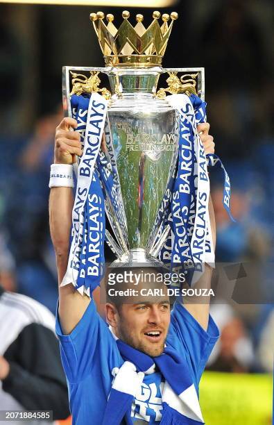 Chelsea's English midfielder Joe Cole celebrates with the Barclays Premier league trophy after Chelsea win the title with a 8-0 victory over Wigan...