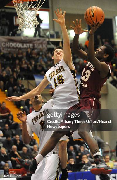 Scotia's Diamond Corker is guarded by Greece Athena's Brendon Wind as he goes up for a basket during the Class A boys' basketball state final on...