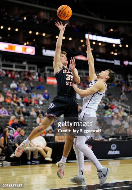 Weston Church of the Oklahoma State Cowboys shoots against Nils Machowski of the UCF Knights during the second half of the Big 12 Men's Basketball...