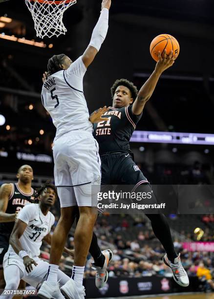 Justin McBride of the Oklahoma State Cowboys shoots against Omar Payne of the UCF Knights during the second half of the Big 12 Men's Basketball...