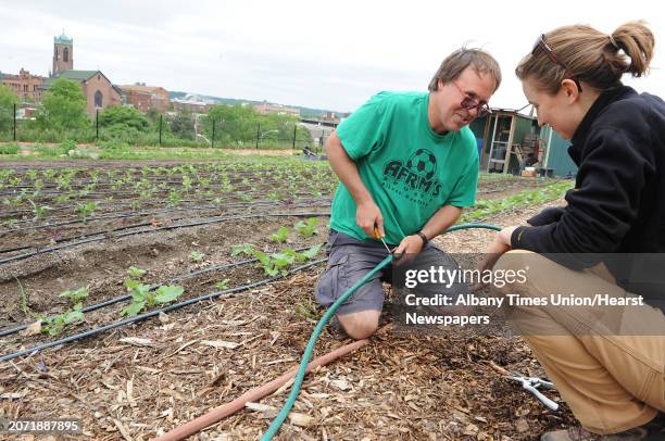 Matthew Schueler, Urban Grow Center planner, and Julia Cosgrove, Produce Project farm manager, fix a hose at the Produce Project youth-powered urban...