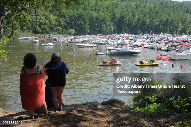 Rosanne Whitton of St. James, left, and her sister Donna Hay of Farmingville watch people party and swim in Log Bay on Lake George on Monday, July...