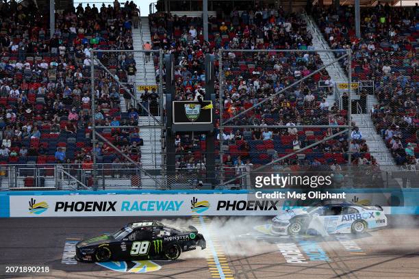 Riley Herbst, driver of the Monster Energy Ford, and Hailie Deegan, driver of the AirBox Ford, spin after an on-track incident during the NASCAR...