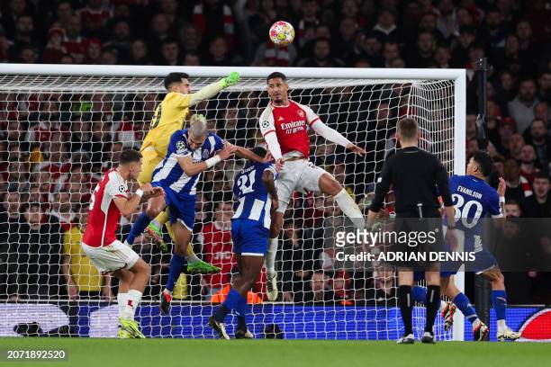Porto's Portuguese goalkeeper Diogo Costa fights for the ball with Arsenal's French defender William Saliba during the UEFA Champions League last 16...