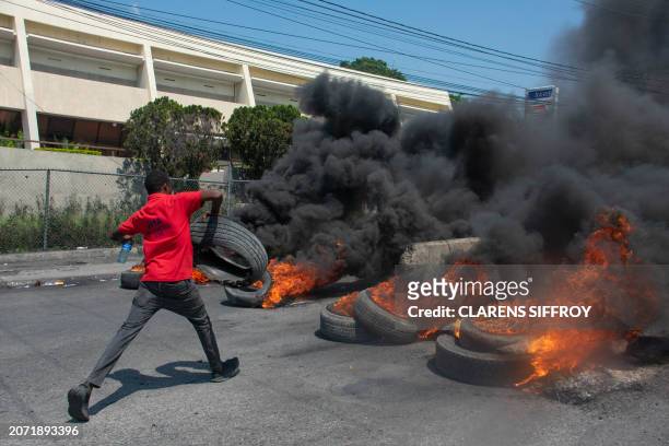 Protester burns tires during a demonstration following the resignation of its Prime Minister Ariel Henry, in Port-au-Prince, Haiti, on March 12,...