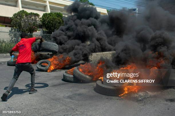 Protester burns tires during a demonstration following the resignation of its Prime Minister Ariel Henry, in Port-au-Prince, Haiti, on March 12,...