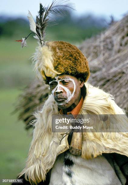 At a small Kikuyu Village near Aberdare National Park in Kenya, this local Kikuyu man dons traditional clothing and paint for a day long festival,...