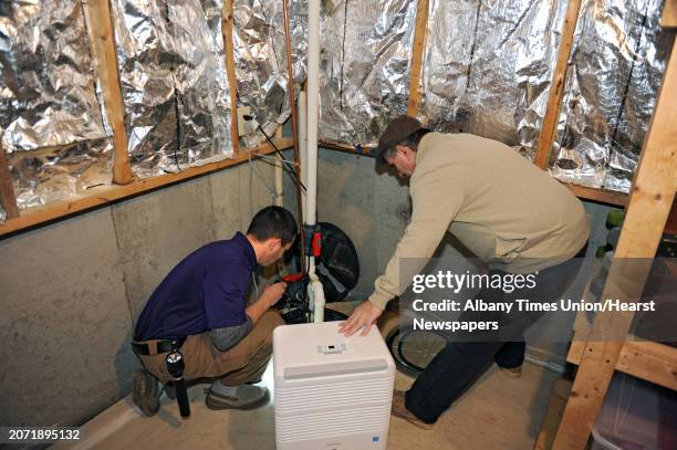 Home inspector Ryan Bergami, left, and his father Tom Bergami check out a sump pump in the basement of a home on Thursday, Feb. 25, 2016 in...