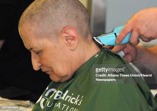 Toni Gallogly of Feura Bush gets her head shaved as students, faculty and administrators shave their heads to raise funds for St. Baldrick's...