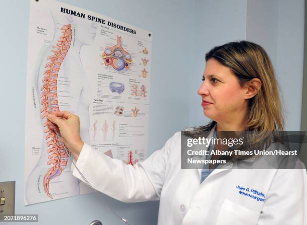Dr. Julie Pilitsis shows where she implants a new spinal stimulation device using a poster in an examination room at Albany Medical Center on Monday,...