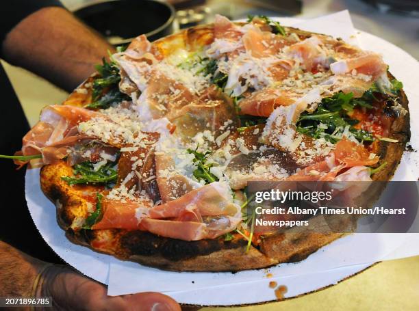 Owner John Isopo holds a Rinaldo pizza at Anna's Wood Fired Pizza on Tuesday, April 21, 2016 in Latham, N.Y. The Rinaldo has fresh mozzarella, tomato...