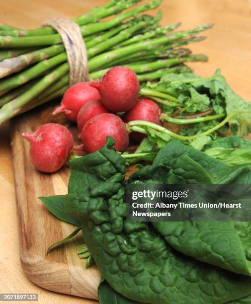 Spinach, radish and asparagus is seen on a kitchen countertop in Caroline Barrett's home on Monday, May 2, 2016 in Delmar, N.Y.