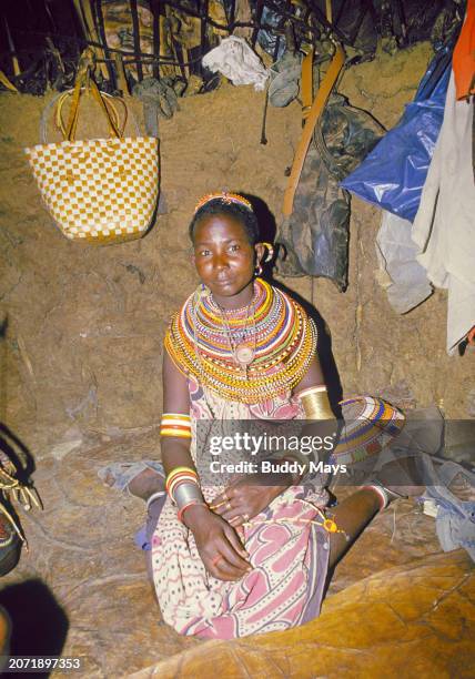 Young Samburu woman inside the hut made of sticks, mud, and blood, that she shares with her husband in a remote Samburu village in Samburu National...