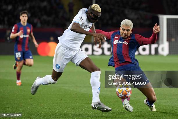 Napoli's Nigerian forward Victor Osimhen and Barcelona's Uruguayan defender Ronald Araujo fight for the ball during the UEFA Champions League last 16...
