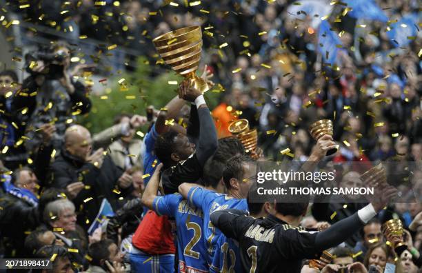 Olympique de Marseille's goalkeeper Steve Mandanda holds the trophy after winning the French League Cup Final football match Lyon vs. Marseille at...