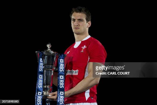 Wales captain Sam Warburton poses for photographers with the trophy during the launch of the Six Nations Rugby Championship in London on January 25,...