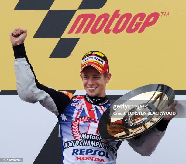 Honda's Casey Stoner of Australia displays his trophy on the podium after winning the Australian Grand Prix motorcycling MotoGP race and securing the...