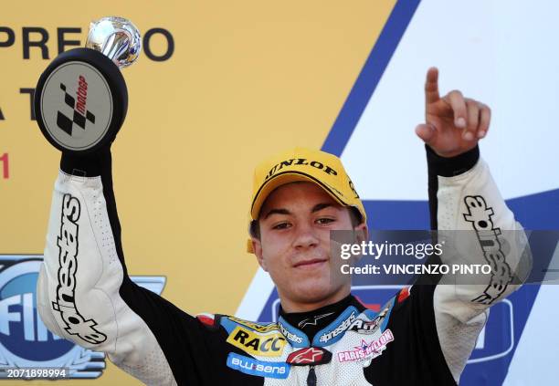 Maverick Vinales of Spain holds the trophy on podium of the 125 cc race of the Italian Grand Prix at Mugello track on July 3, 2011. Nicolas Terol of...