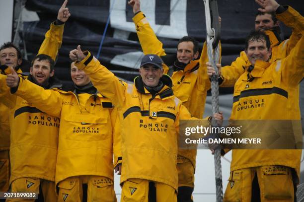 French skipper Loick Peyron and his 13 crew members on board Banque Populaire V thumb up on their vessel, at sea, off the French western city of...