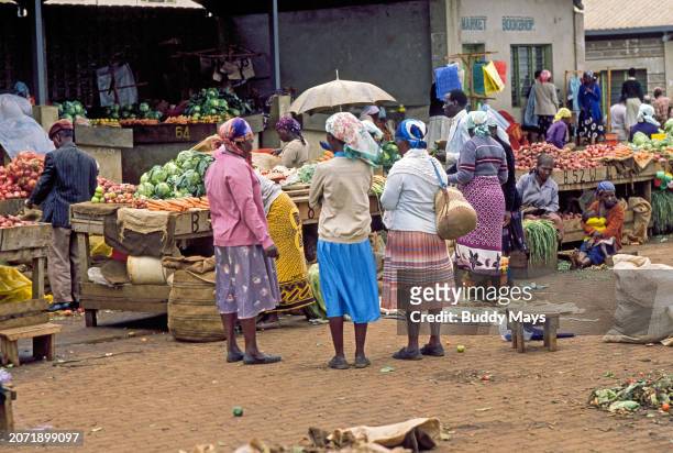 Shoppers and vendors interact in a crowded outdoor market on a Saturday morning in Maralal, Kenya, East Africa, 2000. .