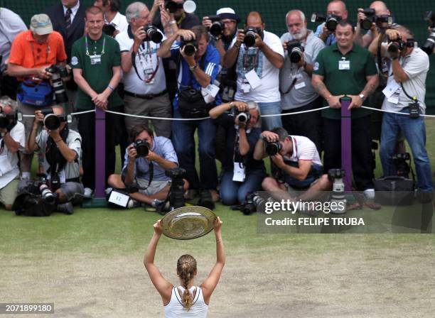 Czech player Petra Kvitova poses with the trophy after beating Russian player Maria Sharapova during the women's final at the Wimbledon Tennis...