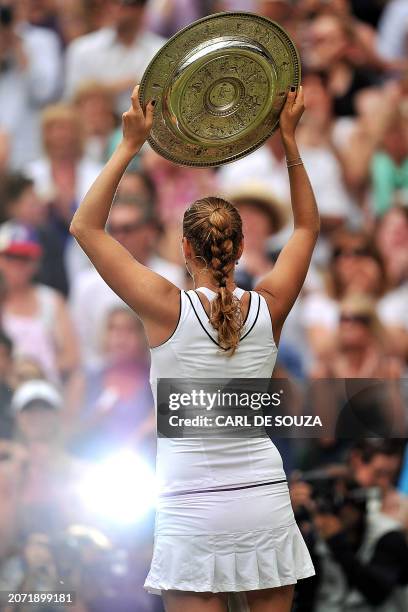 Czech player Petra Kvitova holds the trophy after beating Russian player Maria Sharapova during the women's final at the Wimbledon Tennis...