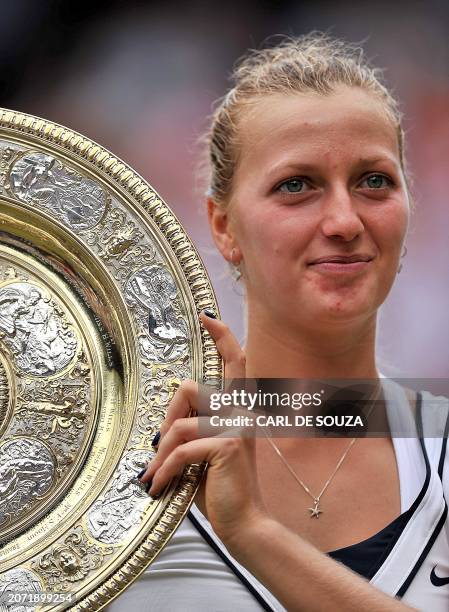 Czech player Petra Kvitova holds the trophy after beating Russian player Maria Sharapova during the women's final at the Wimbledon Tennis...