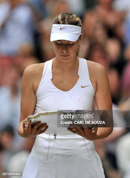 Russian player Maria Sharapova holds the trophy after losing to Czech player Petra Kvitova during the women's final at the Wimbledon Tennis...