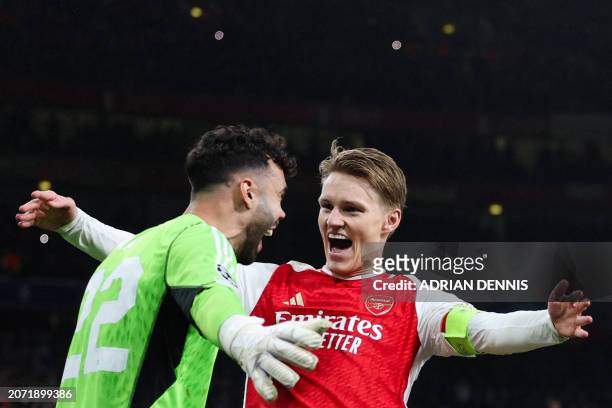 Arsenal's Spanish goalkeeper David Raya and Arsenal's Norwegian midfielder Martin Odegaard celebrate after winning the penalty shoot-out session of...