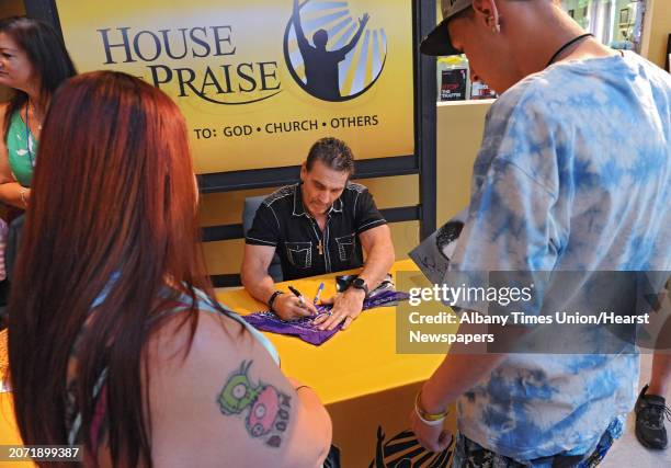 Legend Ken Shamrock signs autographs for Stacy Borey of East Greenish, left, and Frederick Basile of Albany after speaking about his journey at the...