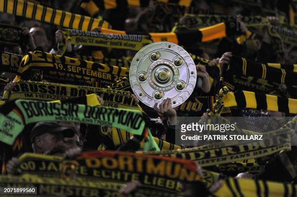 Dortmund fans wave scarves and hold up a replica Bundesliga trophy during the German first division Bundesliga football match Borussia Dortmund vs...