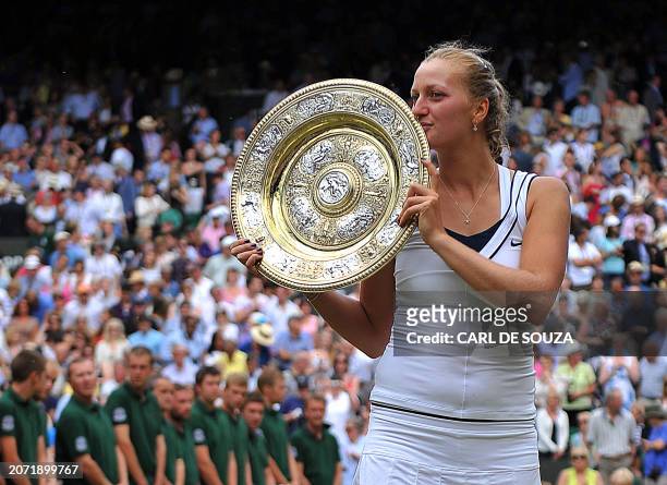 Czech player Petra Kvitova kisses the trophy after beating Russian player Maria Sharapova during the women's final at the Wimbledon Tennis...