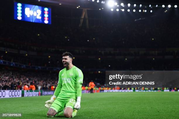 Arsenal's Spanish goalkeeper David Raya celebrates after winning the penalty shoot-out session with his team at the end of the UEFA Champions League...