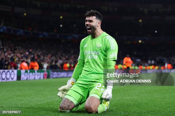 Arsenal's Spanish goalkeeper David Raya celebrates after winning the penalty shoot-out session with his team at the end of the UEFA Champions League...