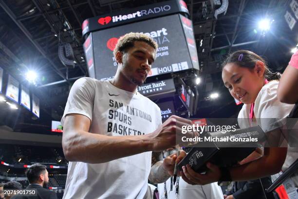 Jeremy Sochan of the San Antonio Spurs autographs memorabilia before the game against the Houston Rockets on March 12, 2024 at the Frost Bank Center...