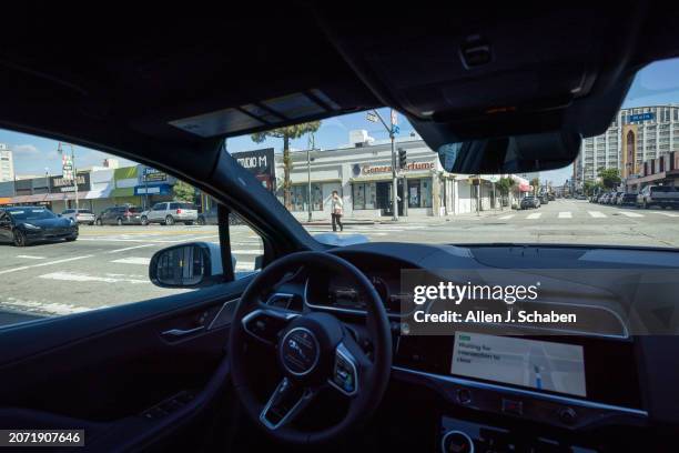 Los Angeles, CA A Waymo robotaxi Jaguar I-PACEs driverless car waits to turn as a passenger crosses the crosswalk in downtown Los Angeles Monday,...