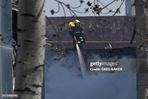 Firefighters extinguish a fire in the aftermath of a suspected gas explosion in Sanhe, in China's northern Hebei province on March 13, 2024. A huge...