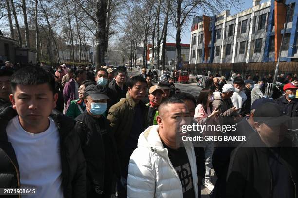 People gather at a police line opposite to the site of a suspected gas explosion in Sanhe, in China's northern Hebei province on March 13, 2024. A...