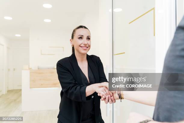 woman at a beauty center kindly receiving a client - one empty desk stock pictures, royalty-free photos & images