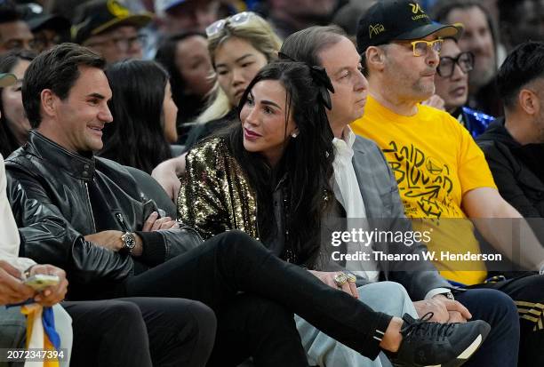 Tennis legend Roger Federer, Nicole Curran, Golden State Warriors owner Joe Lacob, and poker pro Phil Hellmuth sit court side during the second...