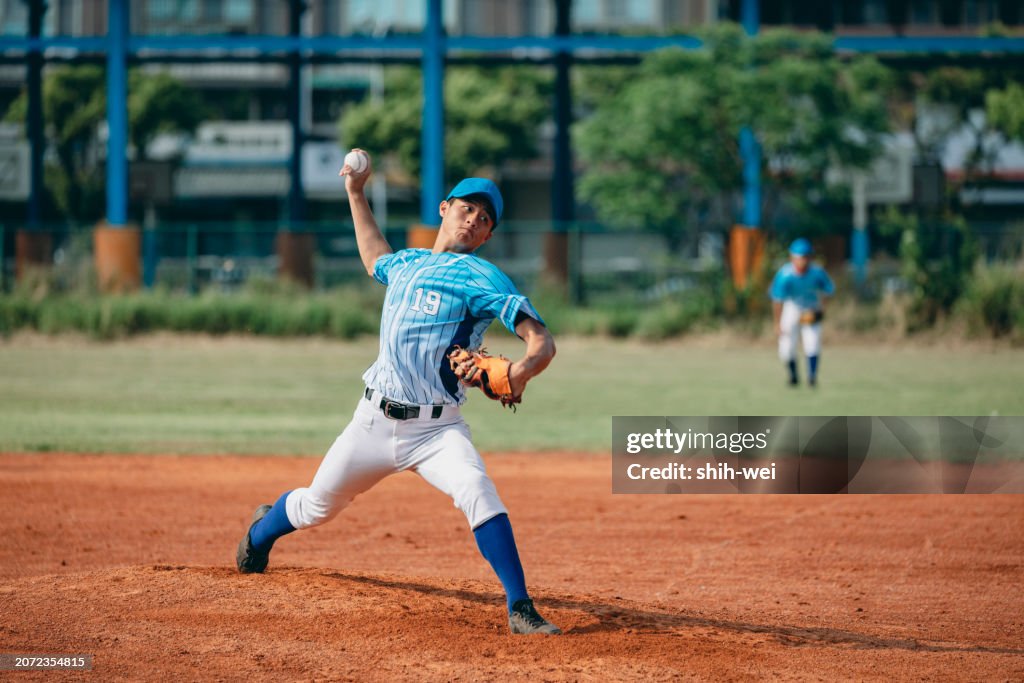 The pitcher throws the ball towards the catcher according to the tactical strategy, focusing and staring ahead, ready to release the ball in that moment.