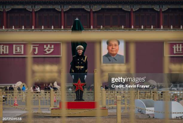 Member of the Peoples Liberation Army honour guard stands next to the national flag, not seen, in Tiananmen Square in front of a large portrait of...