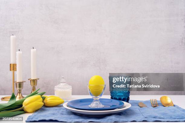 yellow easter egg in eggcup with tulip flowers on table - place mat stock pictures, royalty-free photos & images