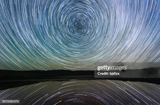 spiegelung von sternenspuren und seeoberfläche - schmuckkörbchen stock-fotos und bilder